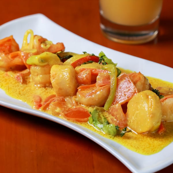 Caribbean shrimp and scallops in a yellow curry sauce with bell peppers and tomatoes.